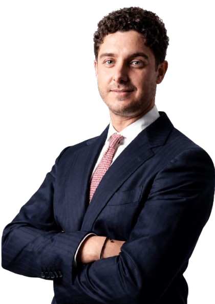 Man in a dark suit and pink tie standing with arms crossed, looking at the camera against a plain white background, exuding confidence as if ready to tackle any challenge at home or in the office.